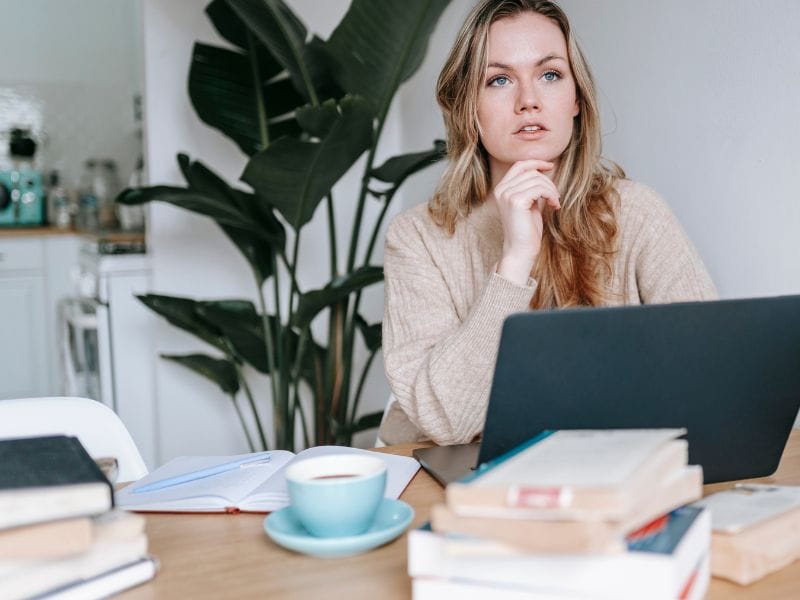 ragazza seduta alla scrivania pensa al budget per comprare casa