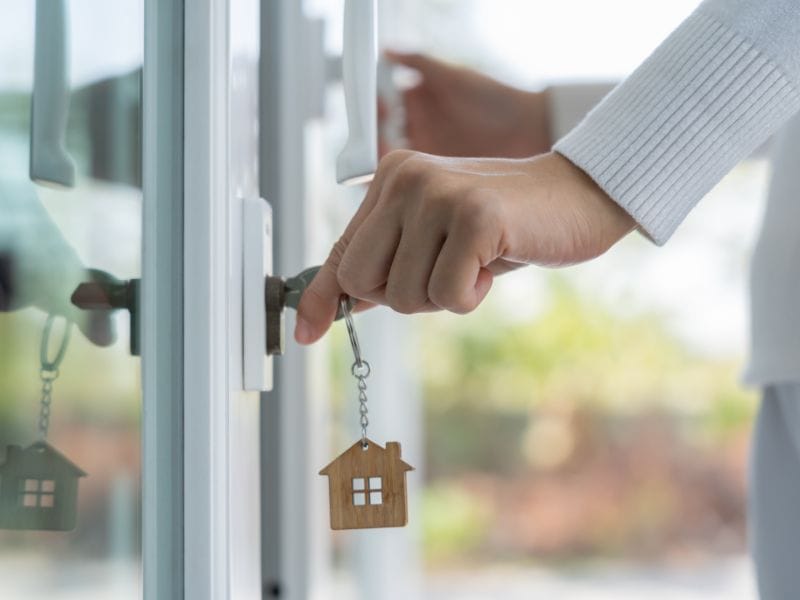 uomo apre la porta di casa con la chiave