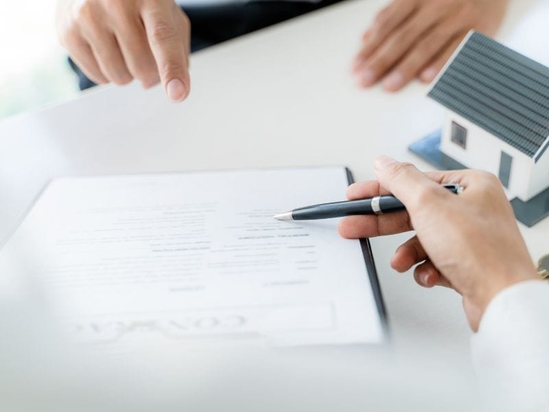 mano mostra con la penna dove firmare