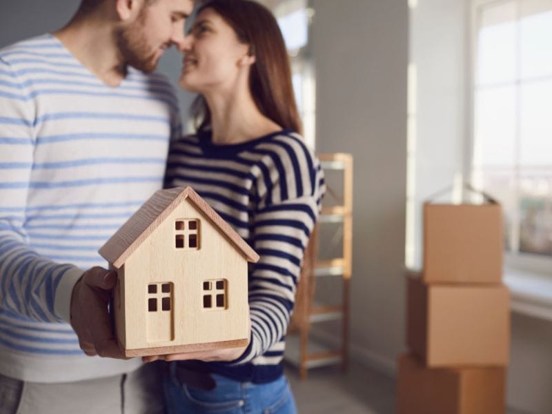 coppia abbracciata con modellino di casa