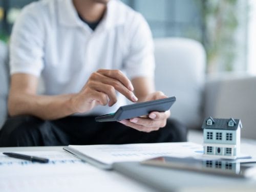 uomo calcola i benefici di dare in affitto una casa a lungo termine