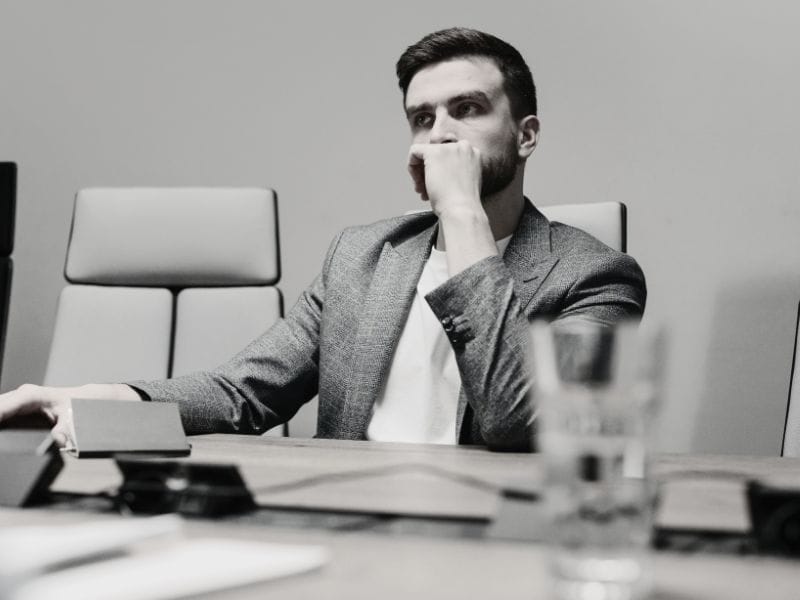 uomo pensa seduto alla scrivania