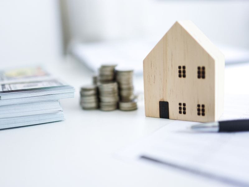 modellino di casa con documenti e denaro