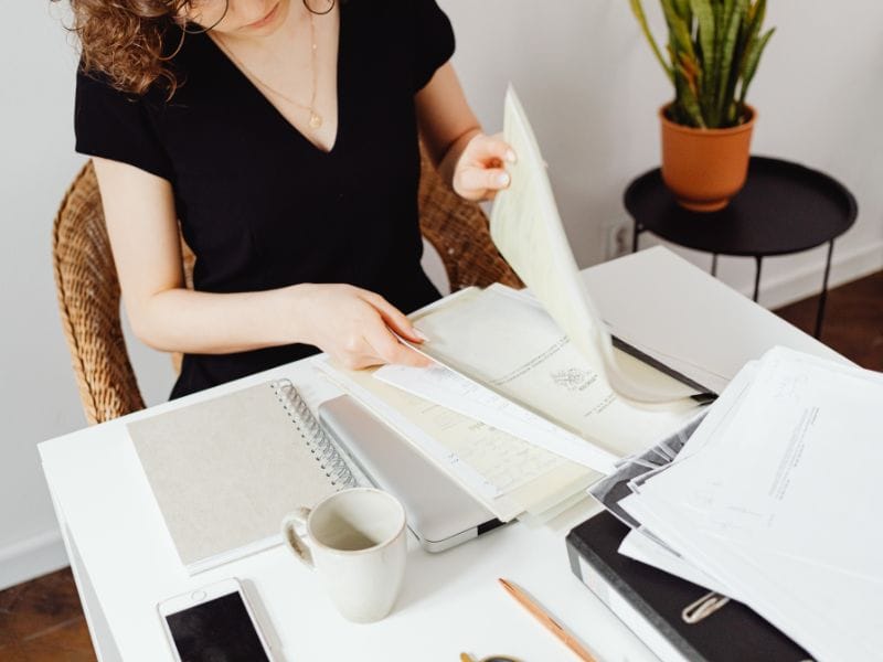 agente immobiliare mette in ordine i documenti di una casa in vendita